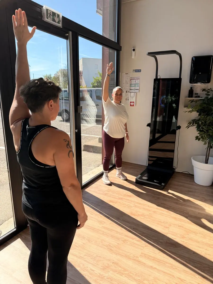 Bras leves devant la borne d'analyse corporelle