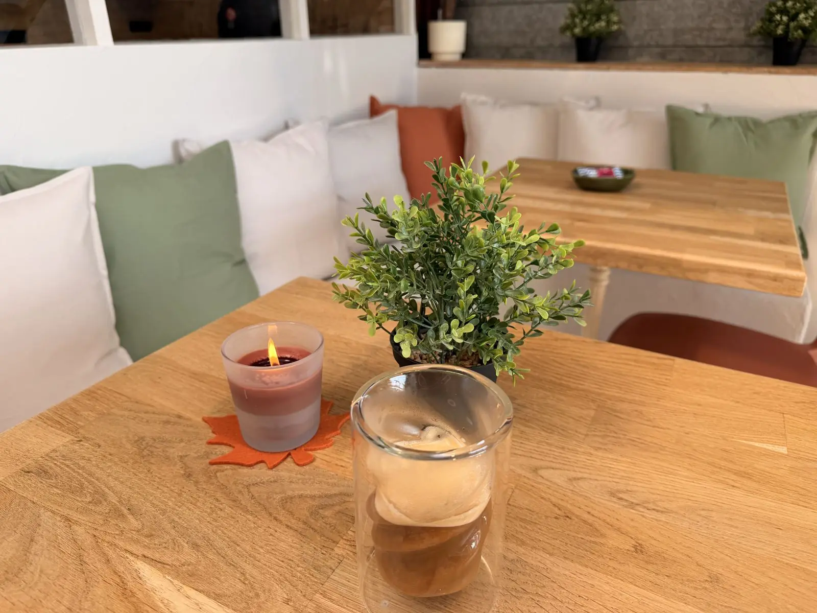 La banquette du coffee bar, un café et une bougie sur la table