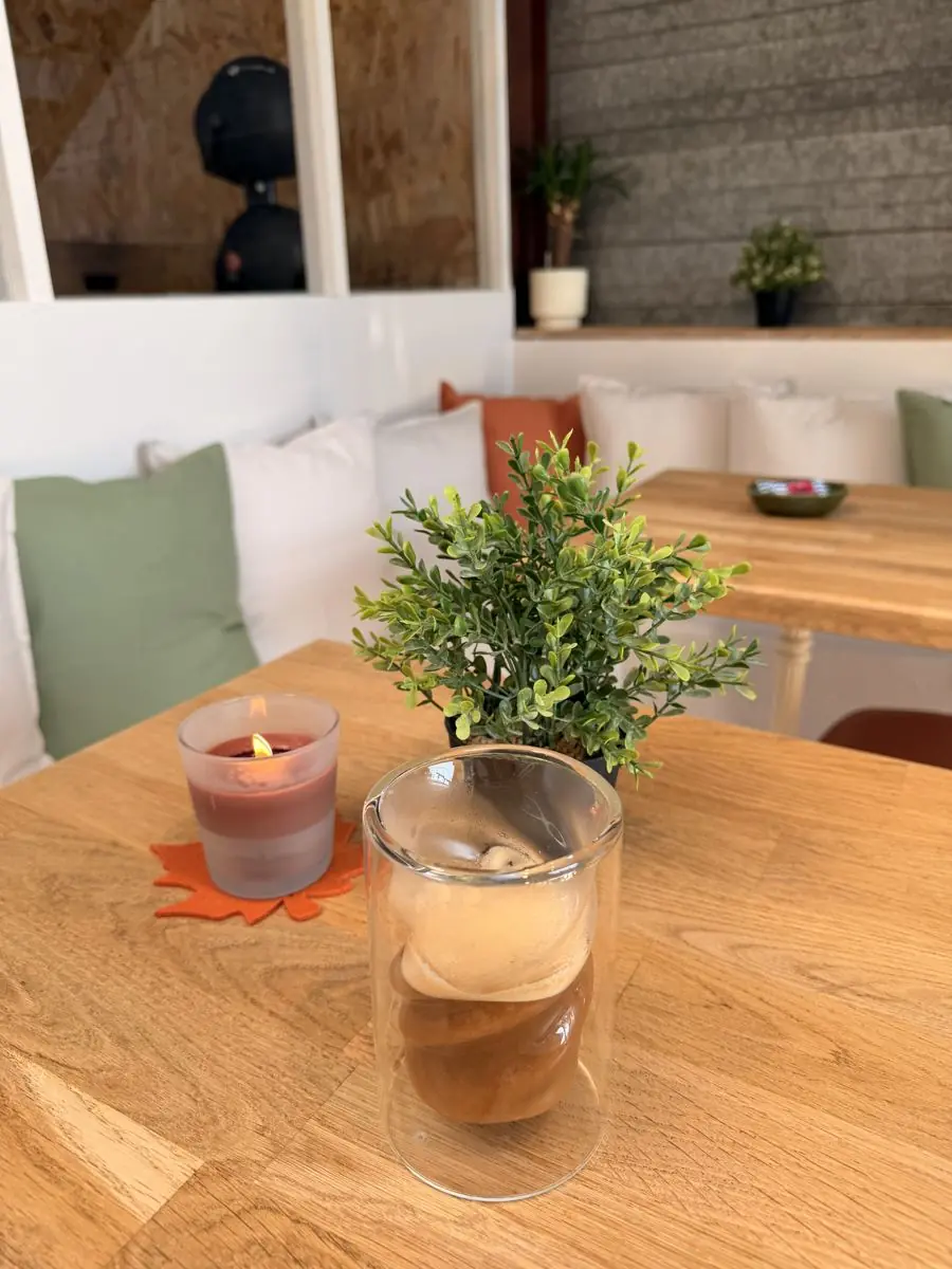 Un café glacé et une bougie sur une table du coffee bar EVERYBODYFIT