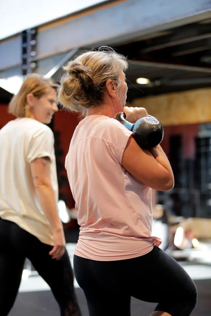 Squat kettlebell pendant une séance en petit groupe