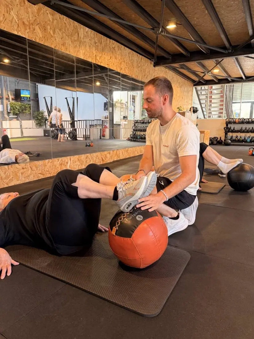 Coach référent EVERYBODYFIT élaborant la stratégie de transformation avec une adhérente autour d'un café